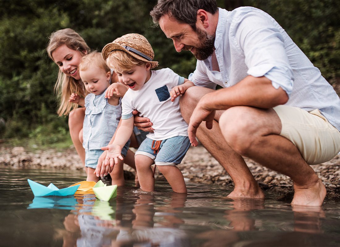 Personal Insurance - Young Family With Two Toddler Children Outdoors by the River in Summer